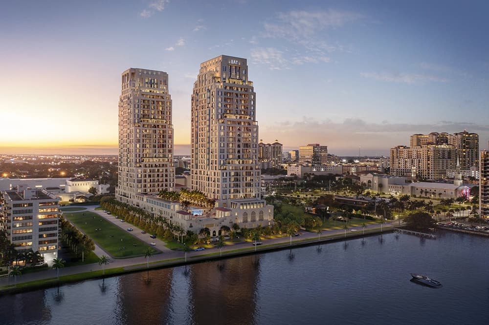 Exterior view of a modern luxury condominium building against a beautiful sunset backdrop.