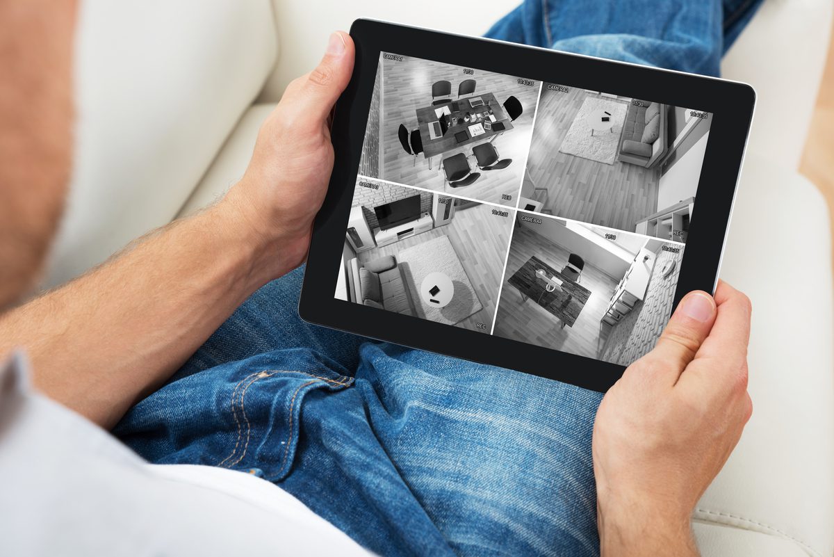 Man Sitting On Sofa And Monitoring Video Footage