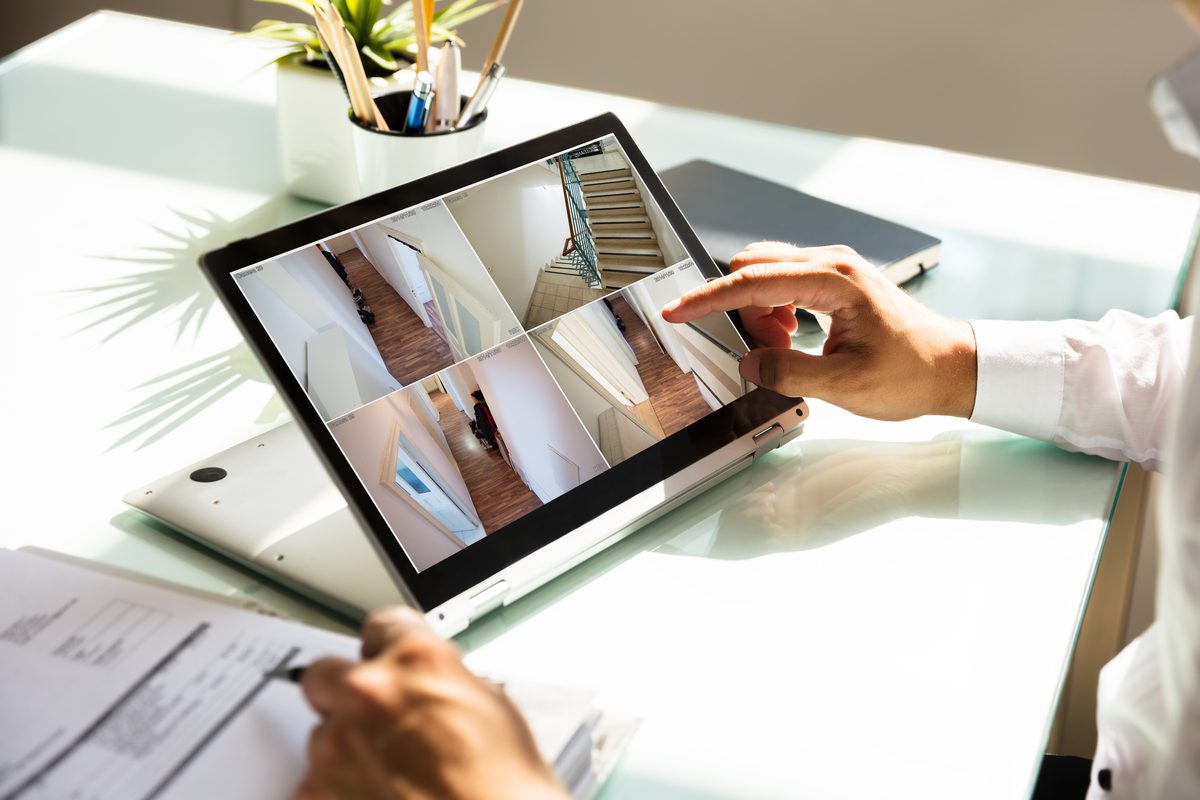 Businessman checking CCTV camera footage on laptop