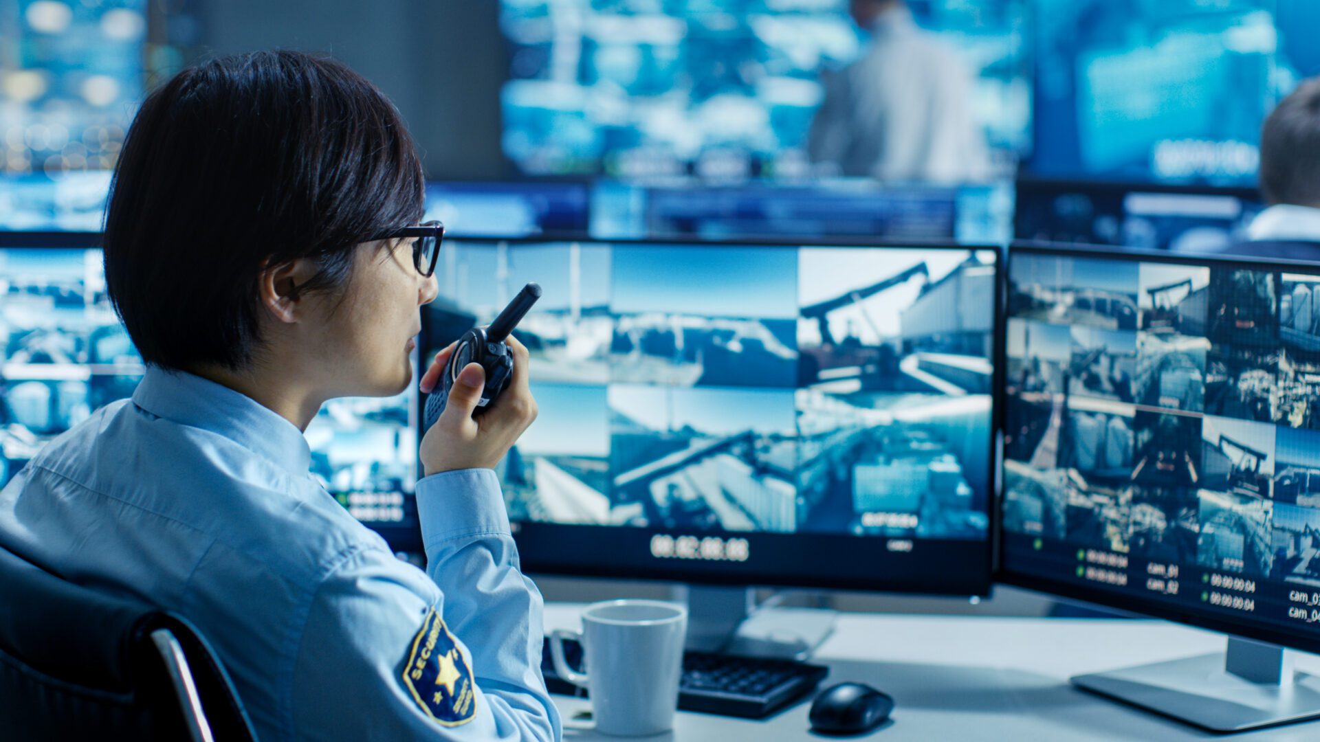 In the Security Control Room Officer Monitors Multiple Screens f