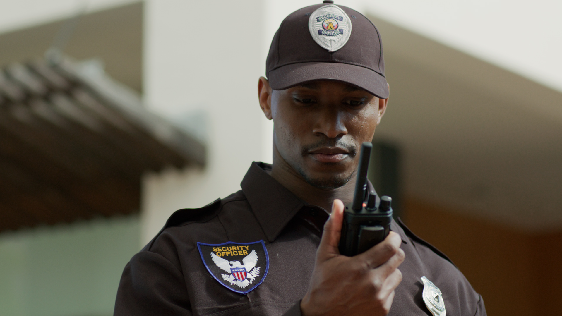 A security guard holding a radio device.