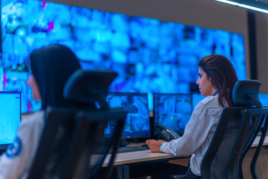 Security personnel monitoring live surveillance footage in a centralized security operations center.